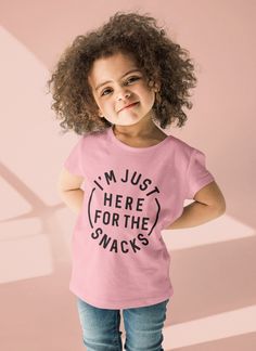 Are you looking for an adorable and funny kids t-shirt for your little bundle of joy? Then you will love this cute "I'm Just Here for the Snacks" tee! This customizable toddler shirt is a real eye-catcher and a visual highlight that you and your kid will absolutely love. It does not only put a smile on people's faces, it is also extremely soft and comfortable. So what are you waiting for? Treat your little one to some stylish new clothes or surprise a friend with a fun gift! PRODUCT INFORMATION ✔ Solid colors: 100% soft ring-spun cotton, heather colors include polyester ✔ Runs true to size ✔ Comes with ribbed knitting for improved durability SHIPPING & PROCESSING TIME 📦 Processing time is currently 1-7 days and will be shipped from U.S. zip code 95131. QUESTIONS? 💬 Have more questions? P Playful Pink T-shirt With Slogan, Pink Playful Tops With Funny Text, Playful Pink Tops With Funny Text, Pink Tops With Funny Text, Playful Crew Neck Top With Funny Text, Kids Tshirt Ideas, Kids Tshirt Designs, Toddler Girl Tees, Here For The Snacks