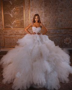 a woman in a white wedding dress posing for a photo with her hands on her hips