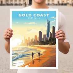 a man holding up a poster with the words gold coast on it in front of a cityscape