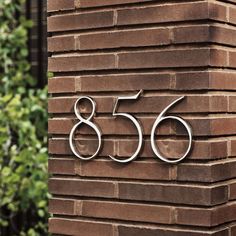 an address sign on the side of a brick building that says,'566 '