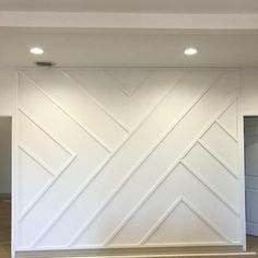 an empty room with white painted walls and wood floors