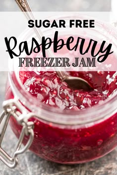 a glass jar filled with raspberry freezer jam on top of a table