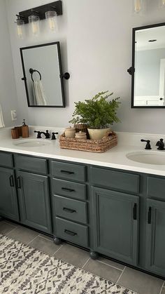 a bathroom with two sinks, mirrors and a rug on the floor in front of it