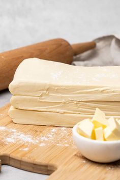 some food is laying out on a cutting board and next to a bowl with butter