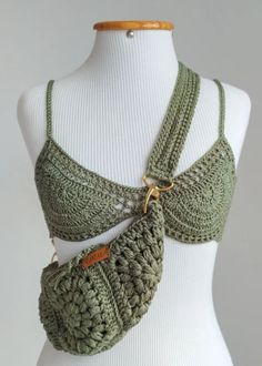 a white mannequin wearing a green crochet bralet with gold hardware