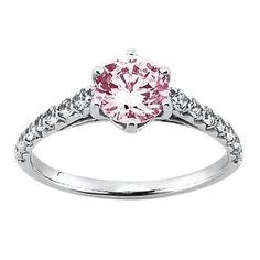 a pink diamond ring with white diamonds on the sides and an accent band around it