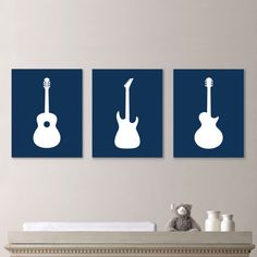 three guitars are hanging on the wall above a crib with a teddy bear in it