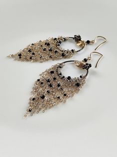 This tassel earring features a combination of black spinel and silver plated Labradorite, with a oxidized silver hoops in the middle and finely crafted textures. The other parts of the metal are matched with 14k gold-filled, and they shine together very brightly and have a gentle feeling, without putting any burden on the earlobes. ●black spinel ●silver plated labradorite ●oxidized silver ●14k gold filled ●mother of pearl flower ● total length: 3.58 inches ● weight：4.8g Welcome to visit my Jewelry store: https://www.etsy.com/shop/Ukuly 🌸The delivery time to Most regions of North America, Australia and Europe is usually about 10-15 days. Buyers from Brazil, South Korea, and Indonesia, please provide me with your tax number through messages or notes for smooth shipment. Thank you. 🌸Please Elegant Tassel Teardrop Earrings, Elegant Teardrop Tassel Earrings, Handmade Elegant Long Drop Chandelier Earrings, Elegant Long Drop Chandelier Earrings With Tassels, Elegant Long Drop Tassel Chandelier Earrings, Bohemian Dangle Earrings For Evening, Luxury Handmade Dangle Chandelier Earrings, Elegant Chandelier Earrings With Dangling Beads For Evening, Elegant Long Drop Fringe Earrings