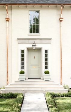 a white house with an entry way leading to the front door