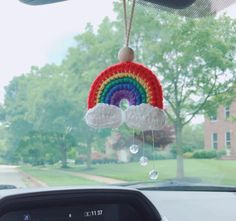 a rainbow decoration hanging from the dashboard of a car