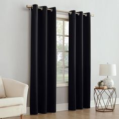 a living room with white walls and black curtains