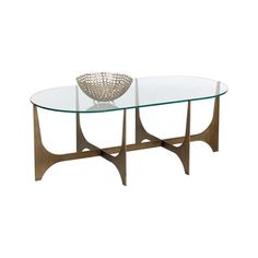 a glass table with metal legs and a bowl on top