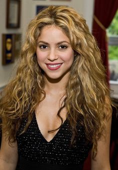 a woman with long blonde hair smiling at the camera