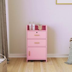 a pink dresser sitting in the corner of a room