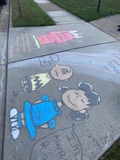 some chalk drawings are on the sidewalk and it looks like they have been drawn by children