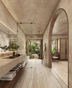 a large bathroom with an arched doorway leading to another room that has a sink and mirror on the wall