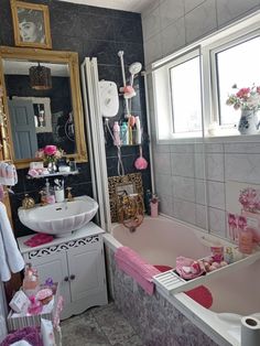 a bath room with a tub a sink and a mirror on the wall next to a window