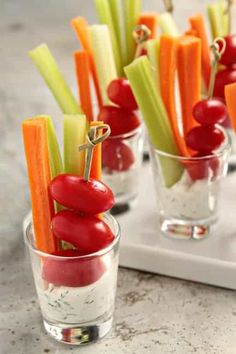 small cups filled with veggies on top of a white tray next to each other