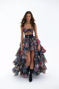 Embody the capricious spirit of Shakespeare's trickster fairy in this two-piece ensemble. A slinky slip dress with a coquettish bow-tied bust meets a voluminous tiered skirt, with an extra-long satin ribbon closure. Scattered blooms dance across the inky canvas, echoing the mischievous footsteps of A Midsummer Night’s Trickster Fairy, Selkie Fall 2023, Selkie Head In The Clouds Ritz Gown, Selkie Runway, Selkie Spring 2023 Runway, Selkie Collection, Silk Dressing Gown, Ruffle Maxi Skirt, Corset Skirt