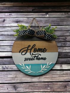 a sign that says home sweethome hanging on the side of a wooden wall