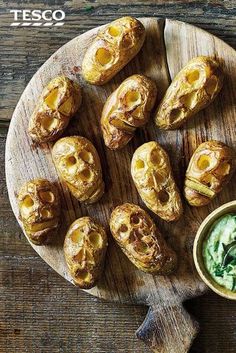 the cover of tesco's cookbook shows baked potatoes on a wooden platter