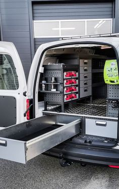 the back end of a white van with its doors open and tools in the cargo compartment