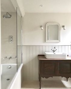 a bathroom with a sink, mirror and bathtub