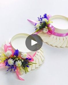 two white baskets with flowers and ribbons on them