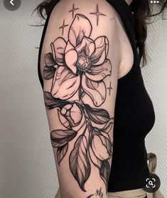 a woman's arm with flowers on it and the cross in the middle is shown