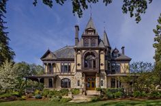 a large house with a tall tower and many windows on it's front porch