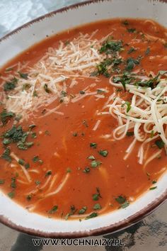 a bowl of soup with noodles and parmesan cheese on the top is ready to be eaten