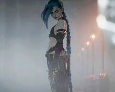 a woman with blue hair standing in front of a street light and wearing futuristic garb