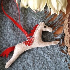 a white horse ornament sitting on top of a table next to a flower