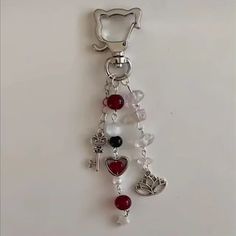 a key chain with various charms hanging from it's side on a white surface