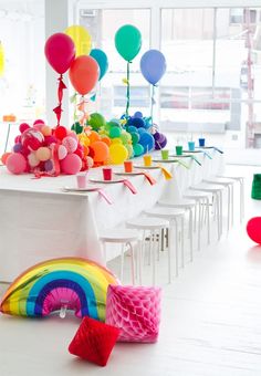 a rainbow themed party with balloons and streamers