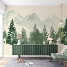 a living room with mountains painted on the wall and green furniture in front of it