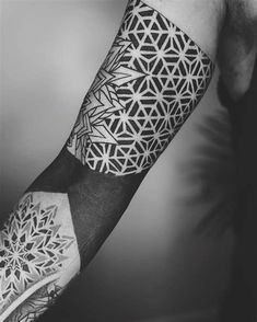 a man's arm with geometric tattoos on it