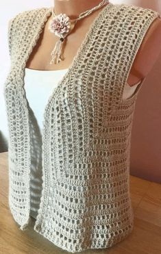 a mannequin wearing a crocheted vest and necklace