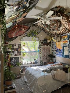 a bedroom with lots of hanging plants and pictures on the walls