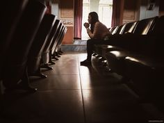 a woman sitting on a bench in front of a window