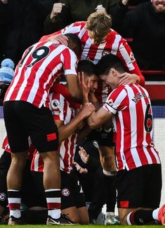 a group of soccer players standing on top of each other