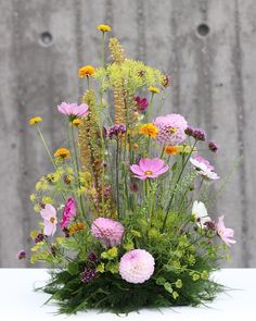 a vase filled with lots of different colored flowers