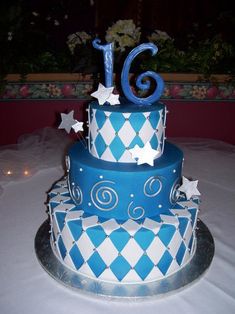 a three tiered blue and white cake with stars on the top is decorated with fondant icing