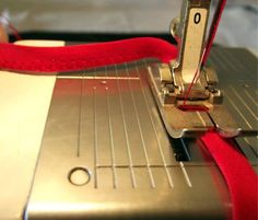 a close up of a sewing machine with a red ribbon on it's side