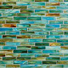 a blue and green tile wall that has been made with glass tiles in different colors