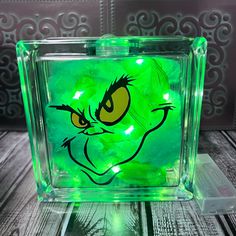 the grin face glows green in this glass block