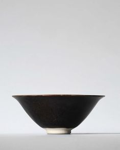 a black bowl sitting on top of a white table