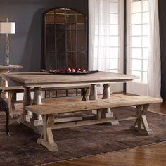 a dining room table and bench in front of a mirror on a wall with windows