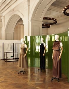 three mannequins dressed in brown and black dresses