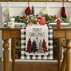 a christmas table runner on top of a wooden table next to a fireplace with stockings and candles